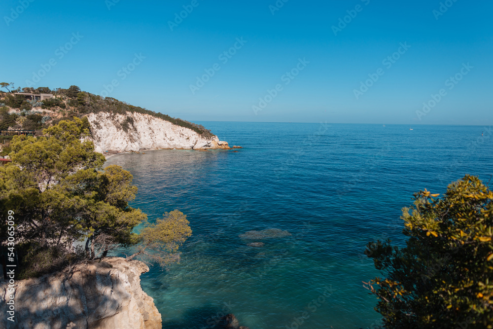 Amazing beautiful clear blue sea with sky, rocks and trees on Elba island, Italy