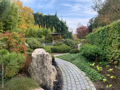 oriental landscape with carved pavement, natural stone boulders, gazebo and traditional east plants. Appeltern, Netherlands, October 12, 2022 photo