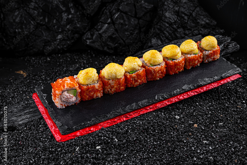 Asian cuisine. Rolls Yamagata. Rice nori caviar tobiko crab avocado parmesan on a black background. Asian cuisine. Rolls Yamagata. Rice nori caviar tobiko crab avocado parmesan on a black background.