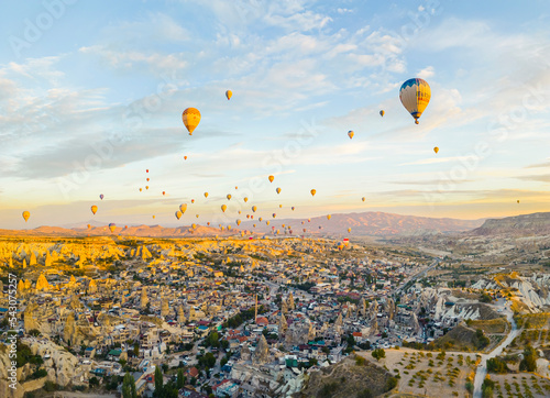 Spectacular drone view of hot air balloons ride over Turkey's iconic Cappadocia, the underground cities and fairy chimneys valley, rock formations. High quality photo