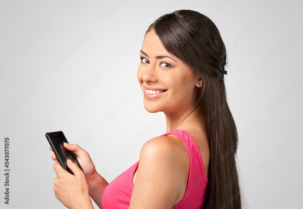 Happy young woman hold a phone and posing Happy young woman hold a phone and posing
