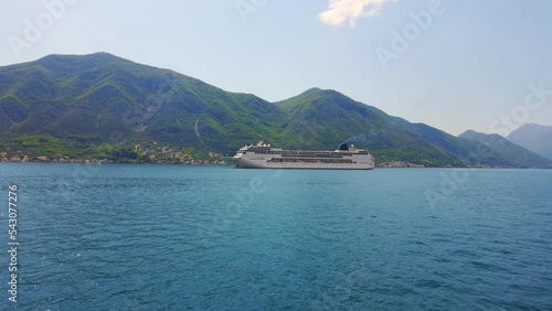 Aerial video. A big cruize ship is moving through the Boka Kotor Bay. Summer in Montenegro. Slowmotion shot photo