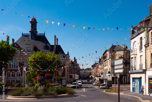 Picturesque summer view of streets decorated with festive garland of small colorful triangular flags in French city