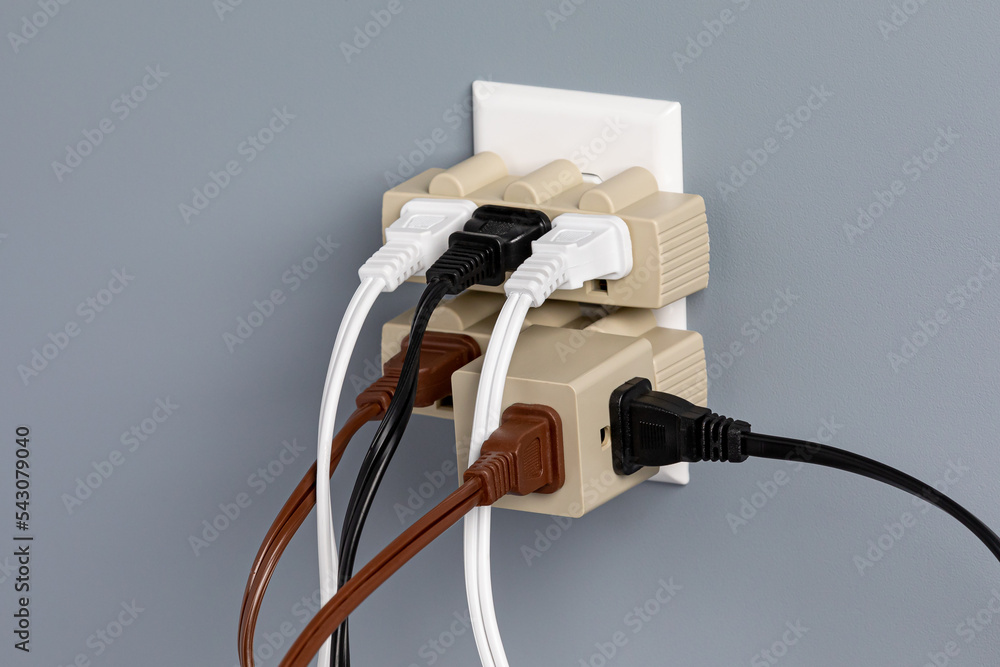 Electrical outlet overloaded with extension cords and adapters. Electricity  safety, fire hazard and circuit overload concept Stock Photo