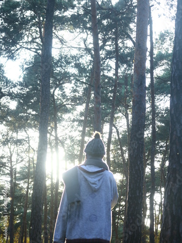 a woman is walking in the forest