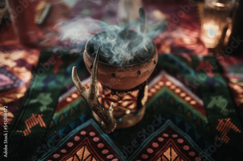 Smoking incense burner with coal on a colorful blanket with indigenous pattern at spiritual ceremony in Tulum photo