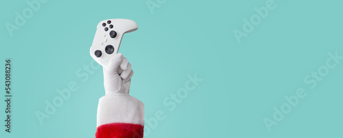 Santa claus hand holding a video game controller - electronic gift concept