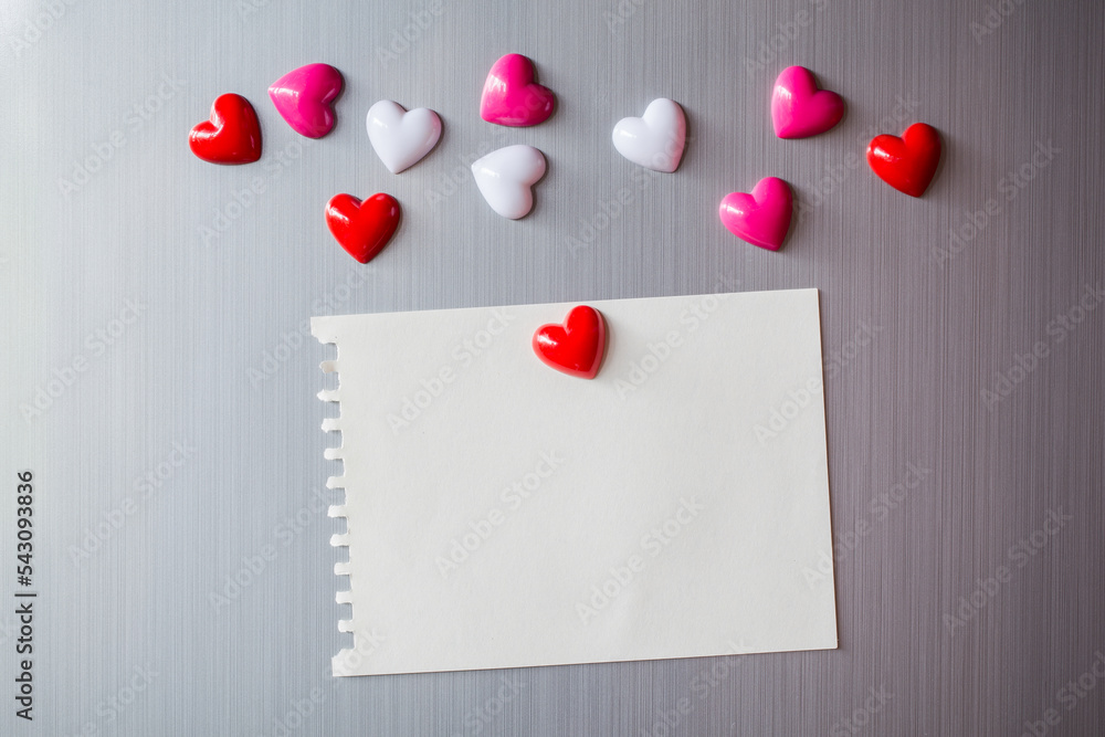 Empty paper sheet on refrigerator door. Note paper with magnetic heart. Valentine send text love message. Empty paper sheet on refrigerator door. Note paper with magnetic heart. Valentine send text love message.