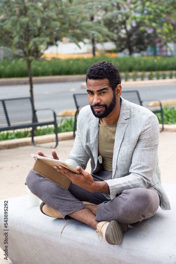 Obraz premium Black man on the street using a tablet