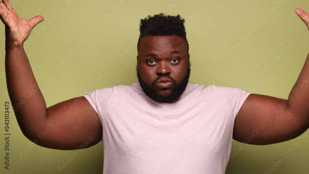 Exhausted tired African-american man in pink t-shirt showing mind explosion gesture, feeling unhappy and nervous, lots unnecessary information. Indoor studio shot isolated on light green background. Exhausted tired African-american man in pink t-shirt showing mind explosion gesture, feeling unhappy and nervous, lots unnecessary information. Indoor studio shot isolated on light green background.
