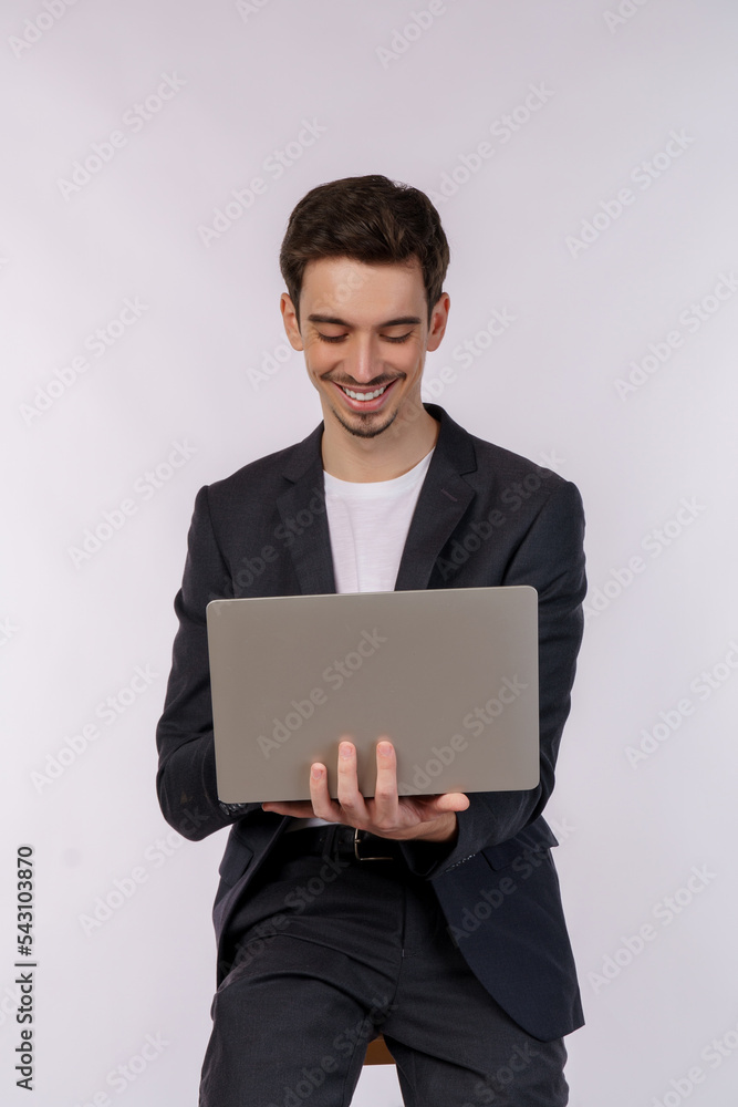 Portrait of young handsome smiling businessman holding laptop in hands, typing and browsing web pages isolated on white background Portrait of young handsome smiling businessman holding laptop in hands, typing and browsing web pages isolated on white background