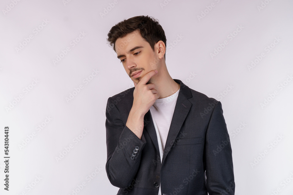 Portrait of young businessman thinking touching chin isolated over white background Portrait of young businessman thinking touching chin isolated over white background