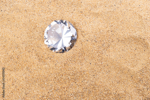 Big Carat Diamond Jewelry Gemstone on Sand Beach in Tropical Island beautiful summer sun on golden find sand, studio shot copy space