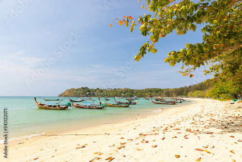 Phuket, Thailand - March 17, 2021: Wooden traditional boat at Rawai Beach with crystal clear water, famous tourist destination and resort area in Southern of Thailand