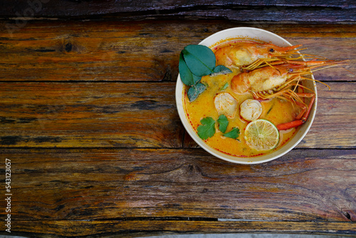 Tom yum kung in a cup on a wooden floor, Tom yum kung is also the national dish of Thailand. And is a food that is famous all over the world.