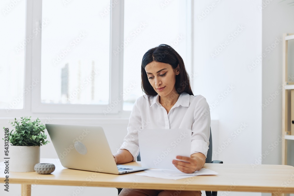 Woman business works at her laptop at home in her office, freelance employee in business, problems with work and paperwork