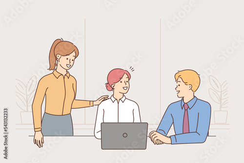 Smiling businesspeople collaborate on computer 