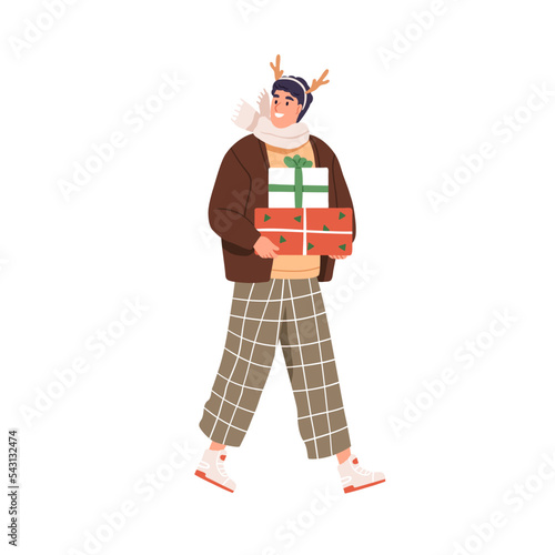 Happy man going with Christmas gift boxes outdoors on winter holidays. Person...