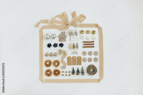Schilderij op canvas Christmas composition with beige ribbon and Christmas decorations: balls, toy trees, ribbons, tags on white background