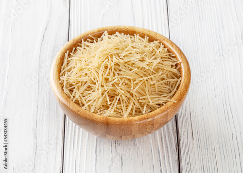 Obraz na płótnie Uncooked filini pasta in wooden bowl on white wooden background w salonie