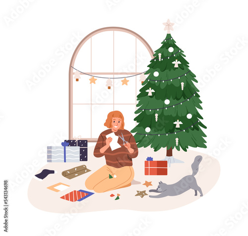 Preparing for Christmas holiday at cozy home. Girl with DIY festive paper dec...