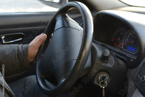 View of the car interior, the driver's hand on the steering wheel. © Михаил Жигалин
