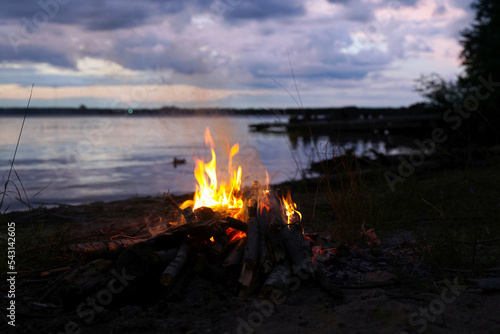 Bonfire on the shore of the lake at sunset