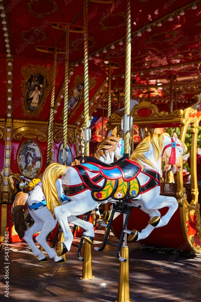 Carousel with horses in the city park. Entertainment for children.