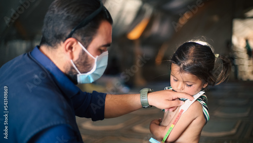 фотографія A doctor examines children's malnutrition inside a refugee camp