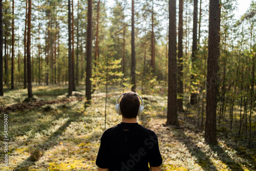 Listening to music in nature with headphones, balance and harmony. A walk in the woods