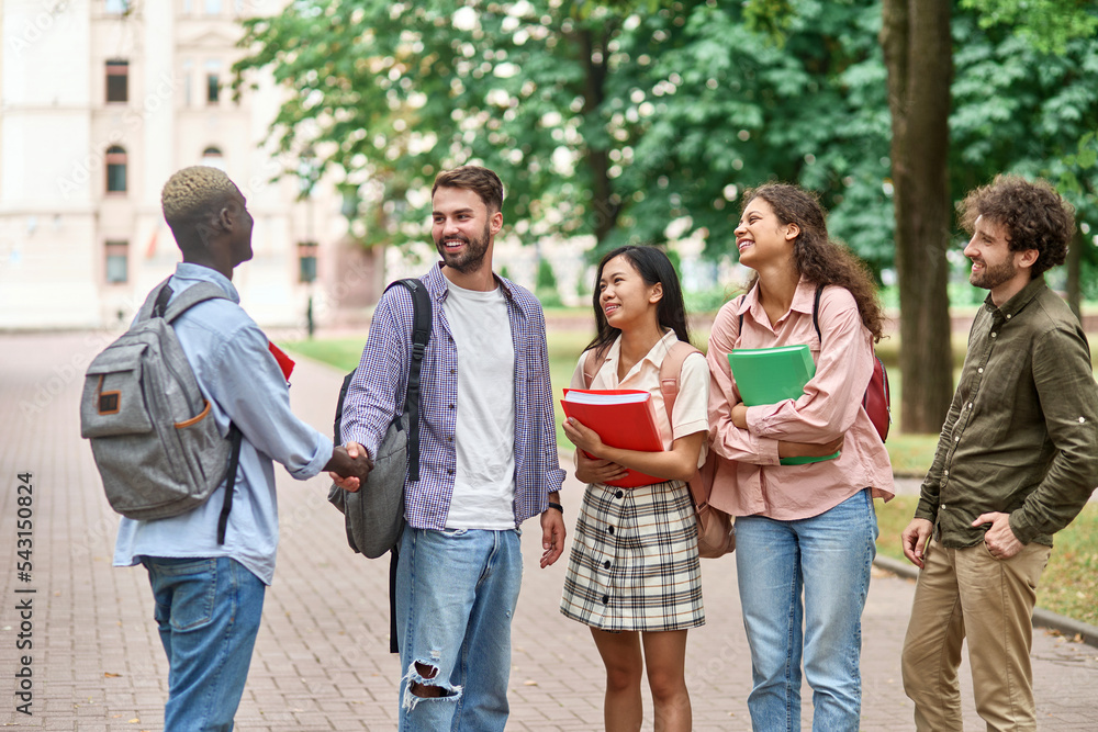 group of students meeting a new friend with a handshake.