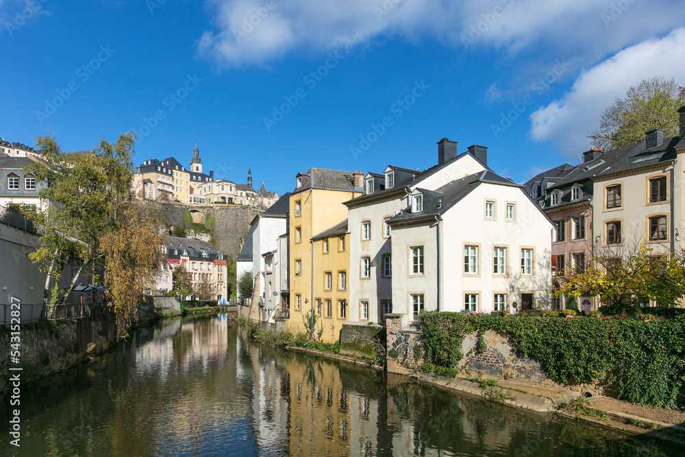 Luxembourg City Grund with Pétrusse River in the sunshine with blue sky and clouds.