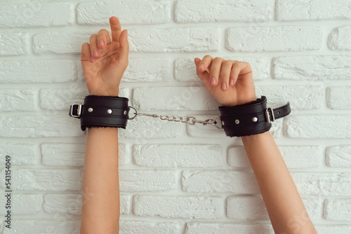 Female hand in black handcuffs for sex games