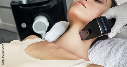 Fotografie Close-up RF neck lifting procedure for young woman for tightening and improving the condition of her skin