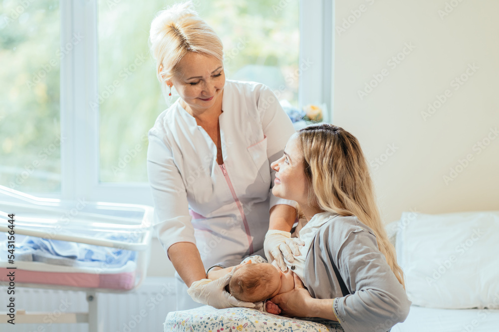 Friendly positive blond female breastfeeding specialist holding new