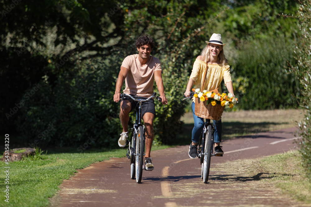 Naklejka premium young smiling couple riding bicycles