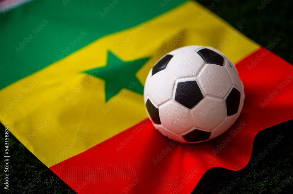 Naklejka premium Senegal national football team. National Flag on green grass and soccer ball. Football wallpaper for Championship and Tournament in 2022. World international match.
