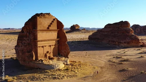 Aerial view of a man running in front of the Tomb Of Lihyan, son of Kuza, Qasr Al Farid, The Lonely Castle in sunny Hegra, Saudi Arabia photo