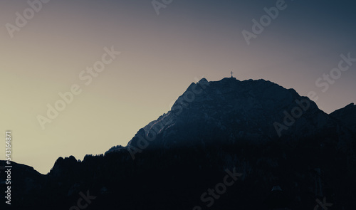 Cinematic view of Caraiman Cross landmark building from the top of Bucegi Mountains in Romania in sunset dusk light.