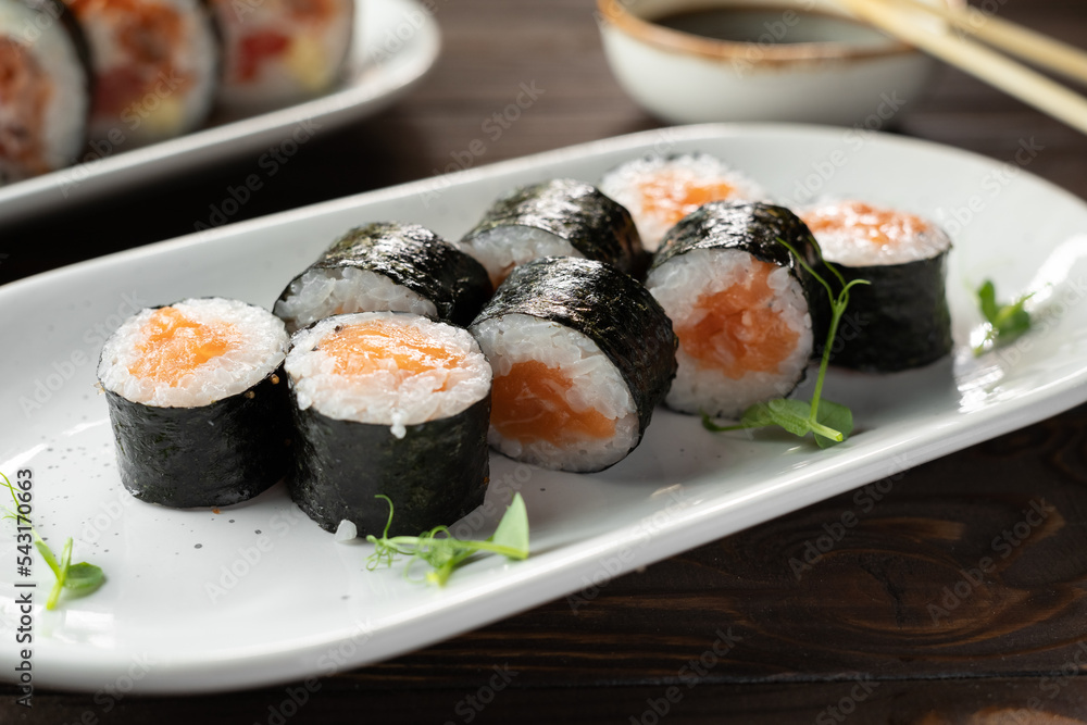 Maki rolls with salmon and cheese on white plate. Sushi menu. Japanese food. Maki rolls with salmon and cheese on white plate. Sushi menu. Japanese food.