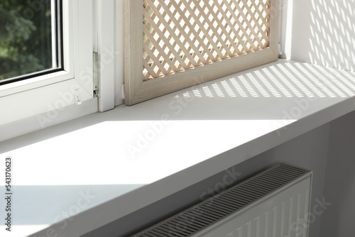 Empty white window sill and decorative wooden shutter indoors