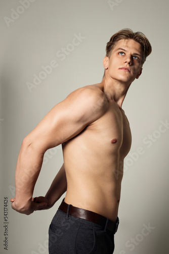portrait of a handsome, serious, athletic man without a T-shirt, showing off his muscles