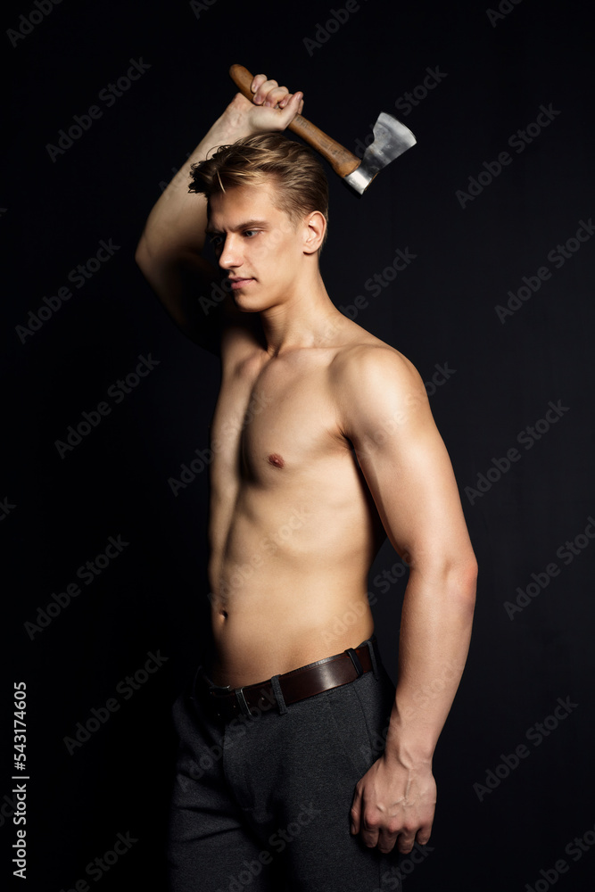 portrait of a man with a naked, inflated torso holding an axe in his hands, swinging it, standing on a black background portrait of a man with a naked, inflated torso holding an axe in his hands, swinging it, standing on a black background