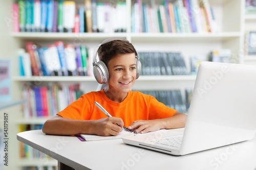 Child do homework with a gadget in room