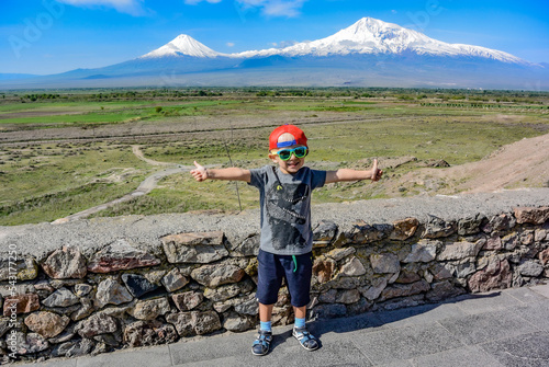Little boy on the background of a beautiful view of mount Ararat in the afternoon. May 6, 2019. Armenia. photo