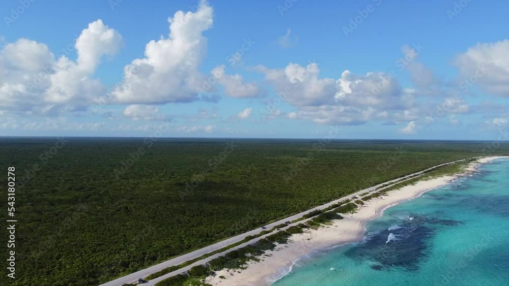 aerial of a vehicle driving on road beside coastline of tropical island Beach in Cozumel Mexico with turquoise water on a sunny summer day aerial of a vehicle driving on road beside coastline of tropical island Beach in Cozumel Mexico with turquoise water on a sunny summer day