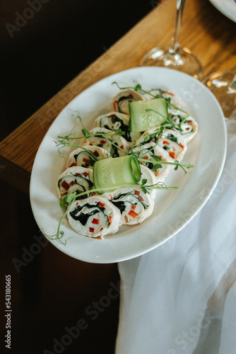 Squid rolls with vegetables, cheese and sauce, buffet