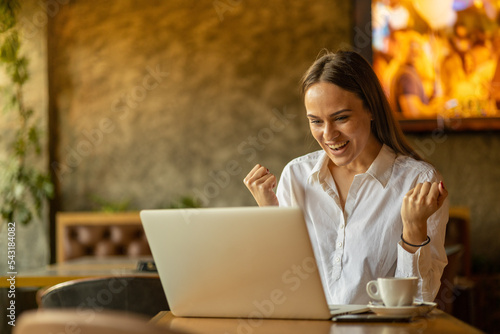 Beautifull young woman working on laptop in cafe
Looking happy and cheerfull photo