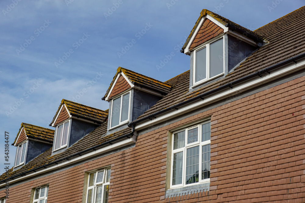 roof tops of housing. Hip roof dormer windows of building. 
