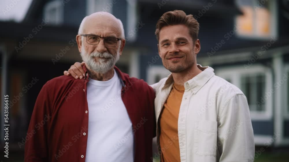 Portrait of a Happy Senior Father or Grandparent Posing Together with His Handsome Adult Son. Family Members Embrace Each Other, Standing, Looking at Camera and Smiling. Portrait of a Happy Senior Father or Grandparent Posing Together with His Handsome Adult Son. Family Members Embrace Each Other, Standing, Looking at Camera and Smiling.
